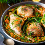 Paella Valenciana with rabbit and chicken presented in a traditional cooking pan.