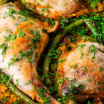 Close-up paella Valenciana with rabbit and chicken presented in a traditional cooking pan.