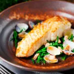 Pan fried halibut fillet with clams and samphire in white wine sauce.