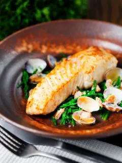 Pan fried halibut fillet with clams and samphire in white wine sauce.