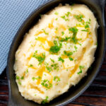 Overhead creamy, buttery and perfectly fluffy mashed potatoes with fresh parsley garnish.