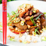 Plum and duck stir fry with crispy skin, toasted peanuts and spring onions.