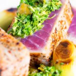 Close-up seared tuna steak with a sauce made from capers, parsley, lemon and olive oil.