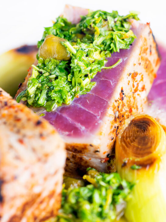 Close-up seared tuna steak with a sauce made from capers, parsley, lemon and olive oil.