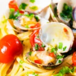 Close-up spaghetti alle vongole or clam pasta with tomatoes, parsley and garlic.