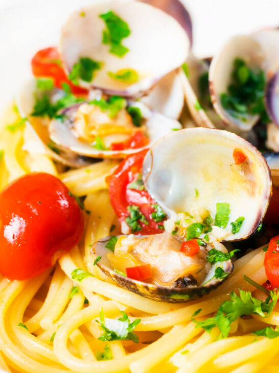 Close-up spaghetti alle vongole or clam pasta with tomatoes, parsley and garlic.