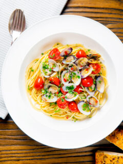 Overhead spaghetti alle vongole or clam pasta with tomatoes, parsley and garlic.