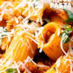 Close-up spicy ground chicken rigatoni with fresh basil and parmesan cheese featuring a title overlay.