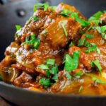 Close-up beef bhuna or bhuna gosht curry in an iron karahi.