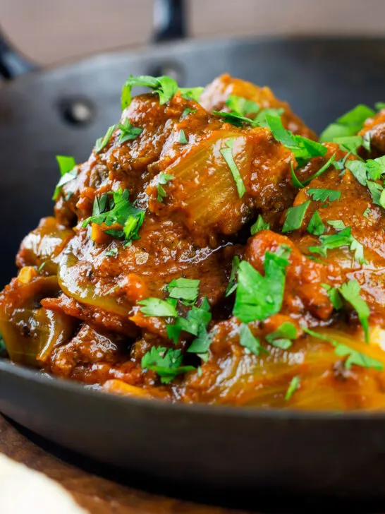 Close-up beef bhuna or bhuna gosht curry in an iron karahi.