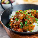 Beef bhuna or bhuna gosht curry with rice, poppadoms and kachumber salad.