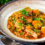 Old fashioned braised rabbit leg stew with pearl barley featuring a title overlay.