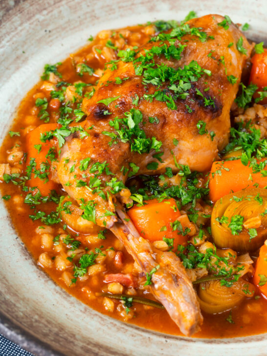 Close-up braised rabbit leg stew with pearl barley, leeks and carrots.