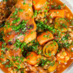 Close-up stewed rabbit with pearl barley, leeks and carrots featuring a title overlay.