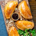 Overhead cheese and onion pasties with Branston pickle in shortcrust pastry.