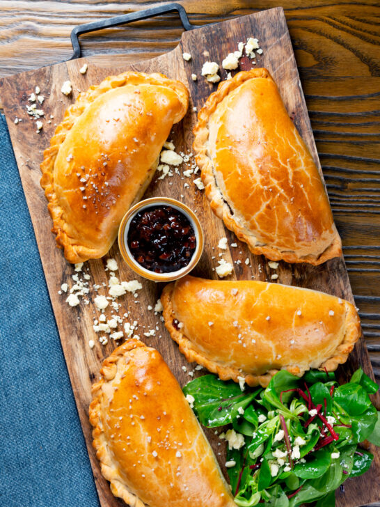 Overhead cheese and onion pasties with Branston pickle in shortcrust pastry.