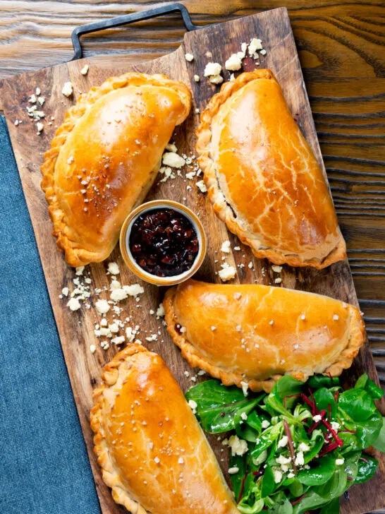 Overhead cheese and onion pasties with Branston pickle in shortcrust pastry.