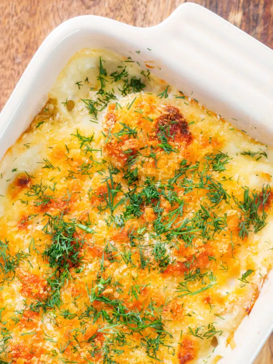 Cheesy smoked haddock and potato gratin and fresh dill featuring a title overlay.