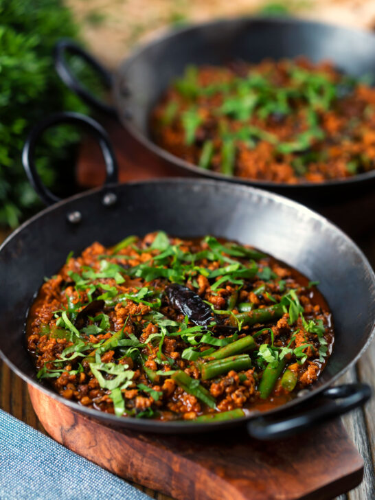 Indian chicken keema curry with green beans served with naan bread.