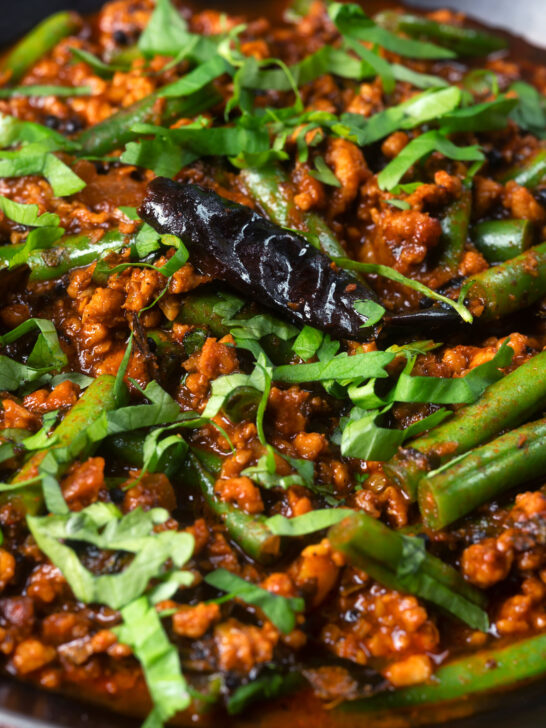 Close-up Indian chicken keema curry with green beans and fresh coriander.