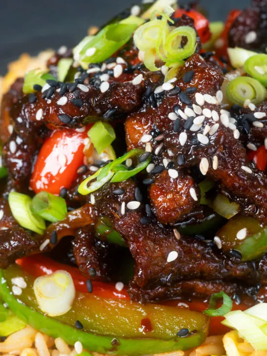 Close-up Chinese takeaway style sticky crispy chilli beef in a sticky sauce.