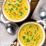 Overhead curried cauliflower veloute soup garnished with turmeric potatoes and coriander featuring a title overlay.