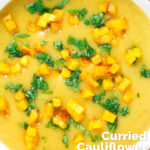 Overhead close-up curried cauliflower veloute soup garnished with turmeric potatoes featuring a title overlay.