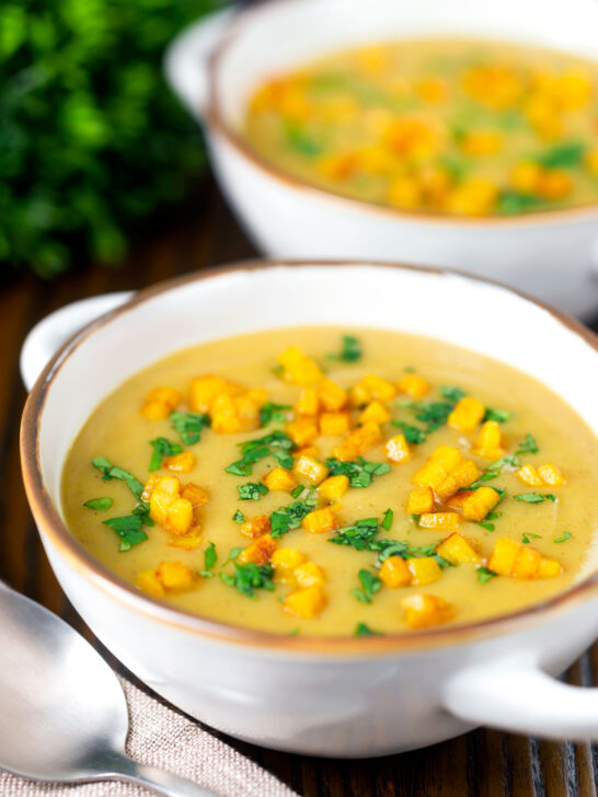 Curried cauliflower veloute soup garnished with turmeric potatoes and coriander.