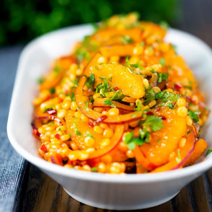 Giant or pearl couscous side salad with rose harissa paste and oranges.