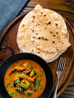 Overhead Indian meal of Ceylon chicken curry with homemade chapati flatbreads.