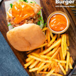 Overhead Korean fried chicken burger with gochujang mayo and kimchi served with fries featuring a title overlay.