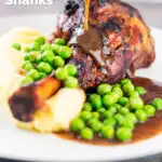 Gravy being poured over minted lamb shanks served with peas and mashed potato featuring a title overlay.