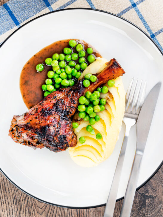 Overhead oven cooked minted lamb shanks served with peas, mashed potato and red wine gravy.
