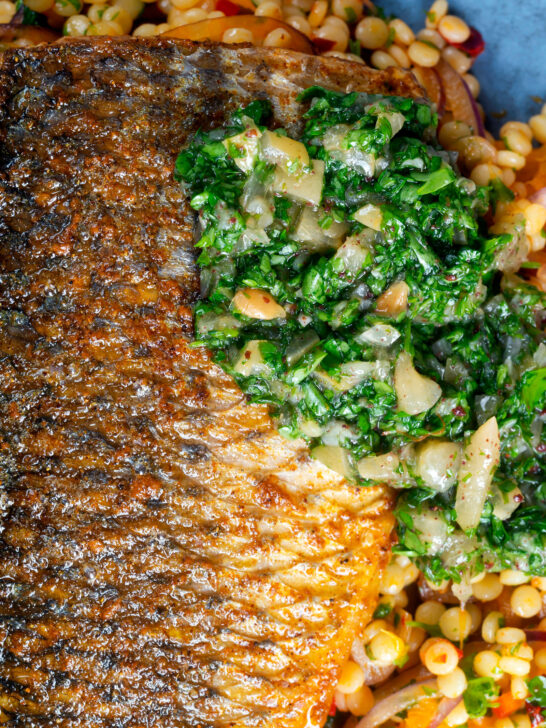 Close-up pan fried grey mullet fillet served with preserved lemons and parsley.