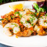 King prawn and chorizo paella with artichoke hearts and green beans.
