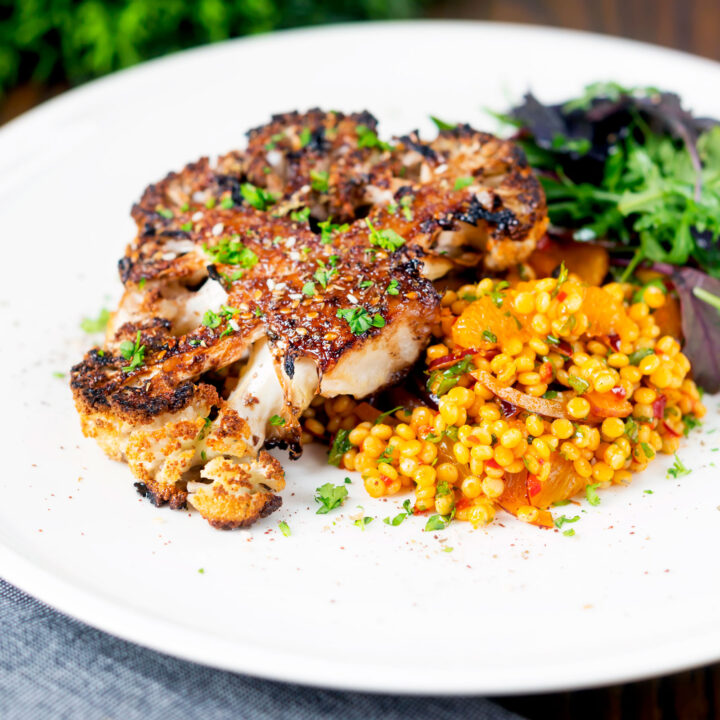 Roasted cauliflower steak glazed with pomegranate molasses served with giant couscous salad.