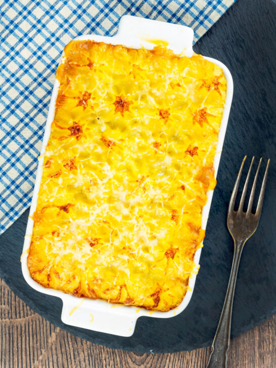 Overhead cheesy mash topped individual vegetarian shepherd's pie or shepherdess pie.