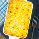 Overhead cheesy mash topped individual vegetarian shepherd's pie or shepherdess pie featuring a title overlay.