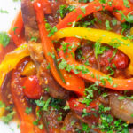 Close up Crock Pot pork chops with peppers, tomatoes and Worcestershire sauce.
