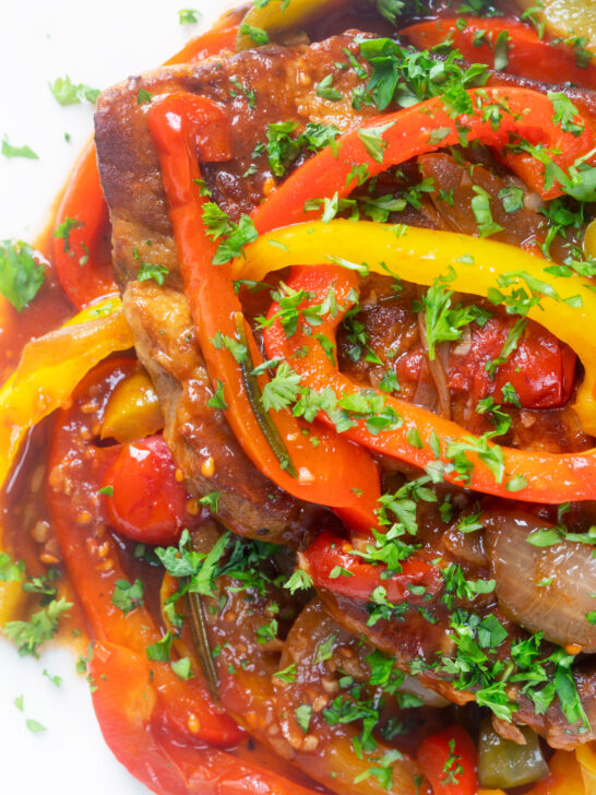 Close up Crock Pot pork chops with peppers, tomatoes and Worcestershire sauce.