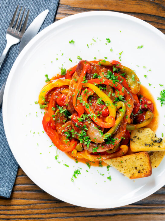 Overhead slow cooker pork chops with peppers, tomatoes and Worcestershire sauce.