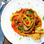 Overhead slow cooker pork chops with peppers, tomatoes and Worcestershire sauce featuring a title overlay.