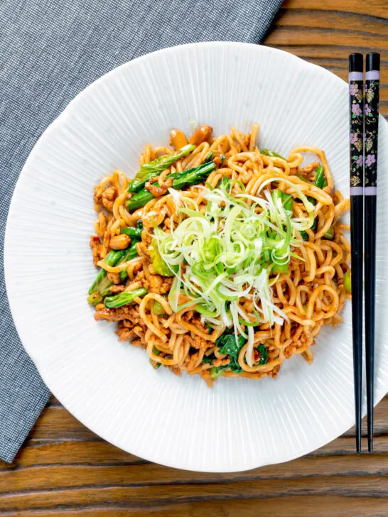 Overhead dan dan noodles, a spicy pork mince stir fry with peanuts and chilli with spring onions.