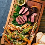 Overhead surf and turf sharing board with langoustine, steak and samphire.