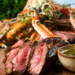 Close-up image of steak cooked pink as part of a surf and turf dinner.