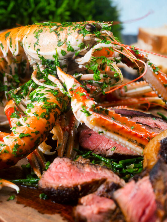 Close-up shell on langoustine at the centre of a surf and turf platter.