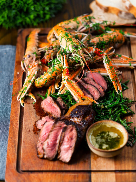 Surf and turf sharing board with steak, langoustine, garlic butter and samphire.