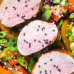 Overhead close-up roasted sweet and sour pork tenderloin with mixed peppers.
