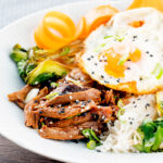 Wagamama inspired shredded teriyaki duck donburi rice dish with a fried egg.