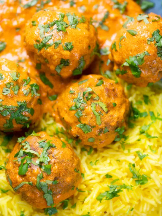 Overhead close-up venison meatballs in an Indian-style yoghurt-based curry sauce with pilau rice.